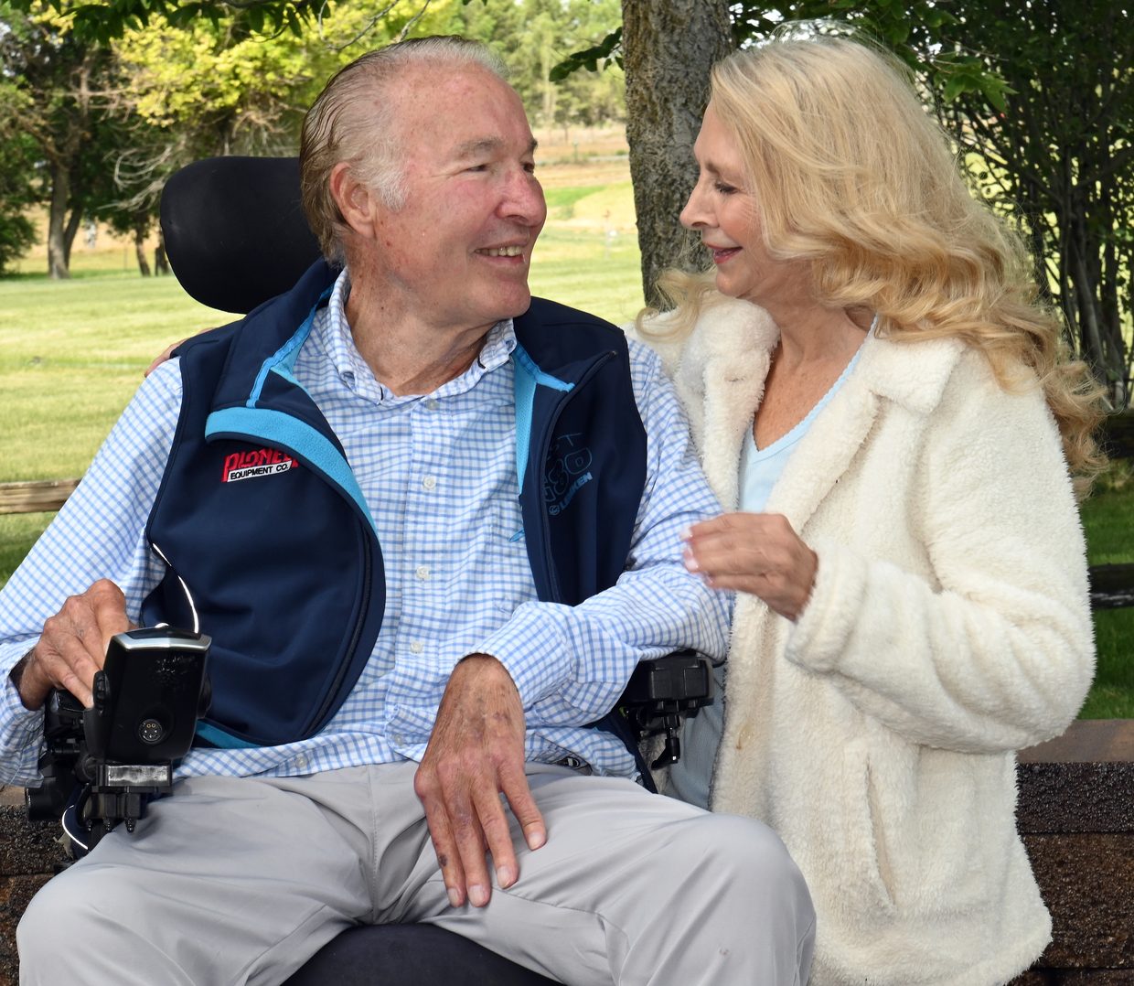 Two members of the Wray family sharing a smile outdoors under the trees