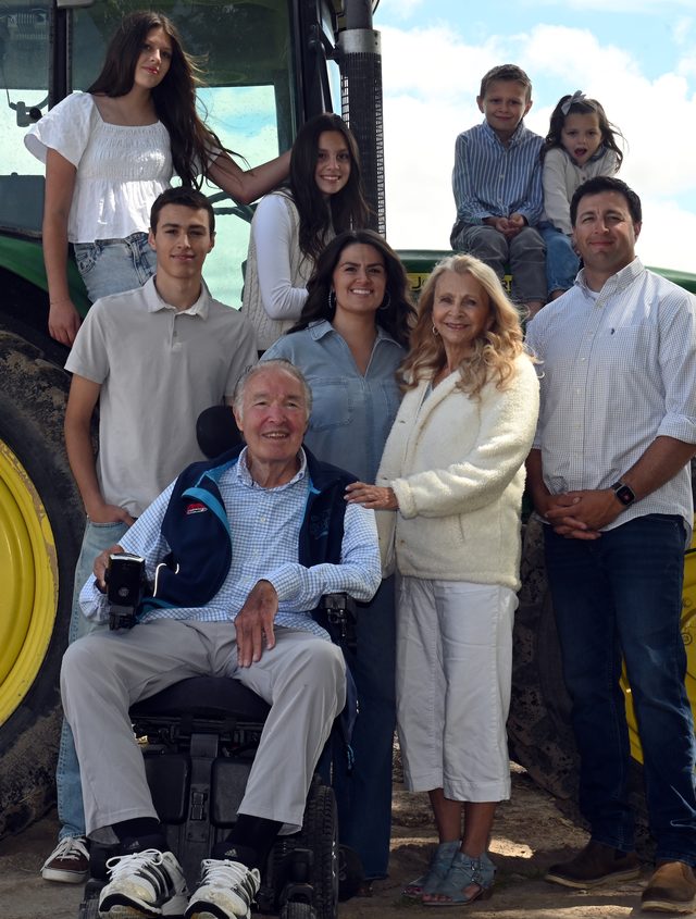 The extended Wray family gathered in front of a green tractor